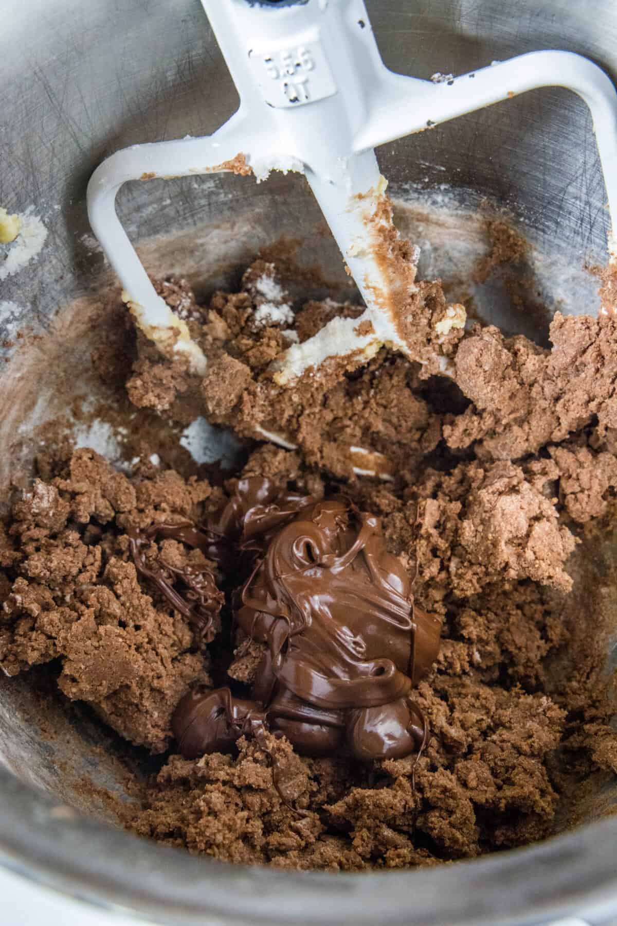 adding melted chocolate to cookie dough