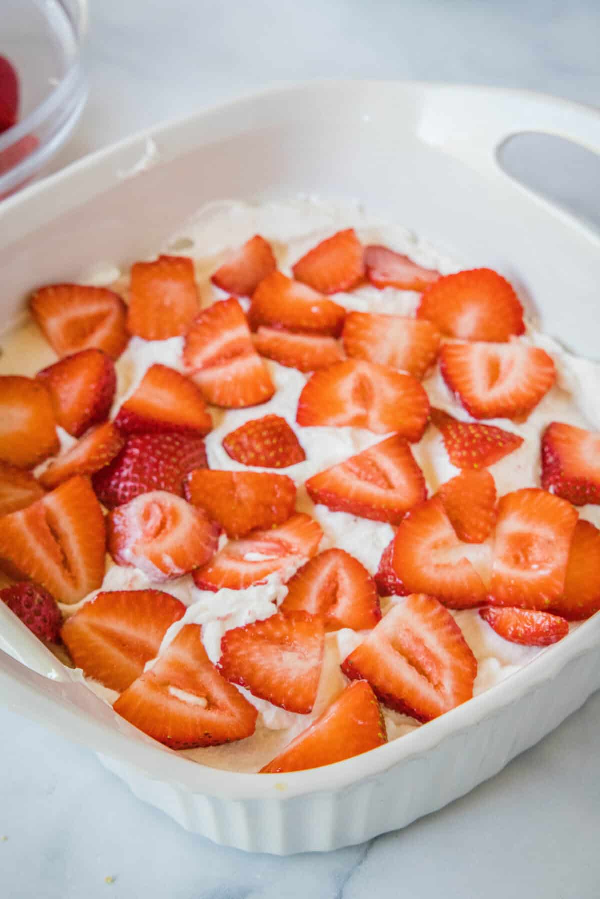 adding strawberry layer to ice box cake