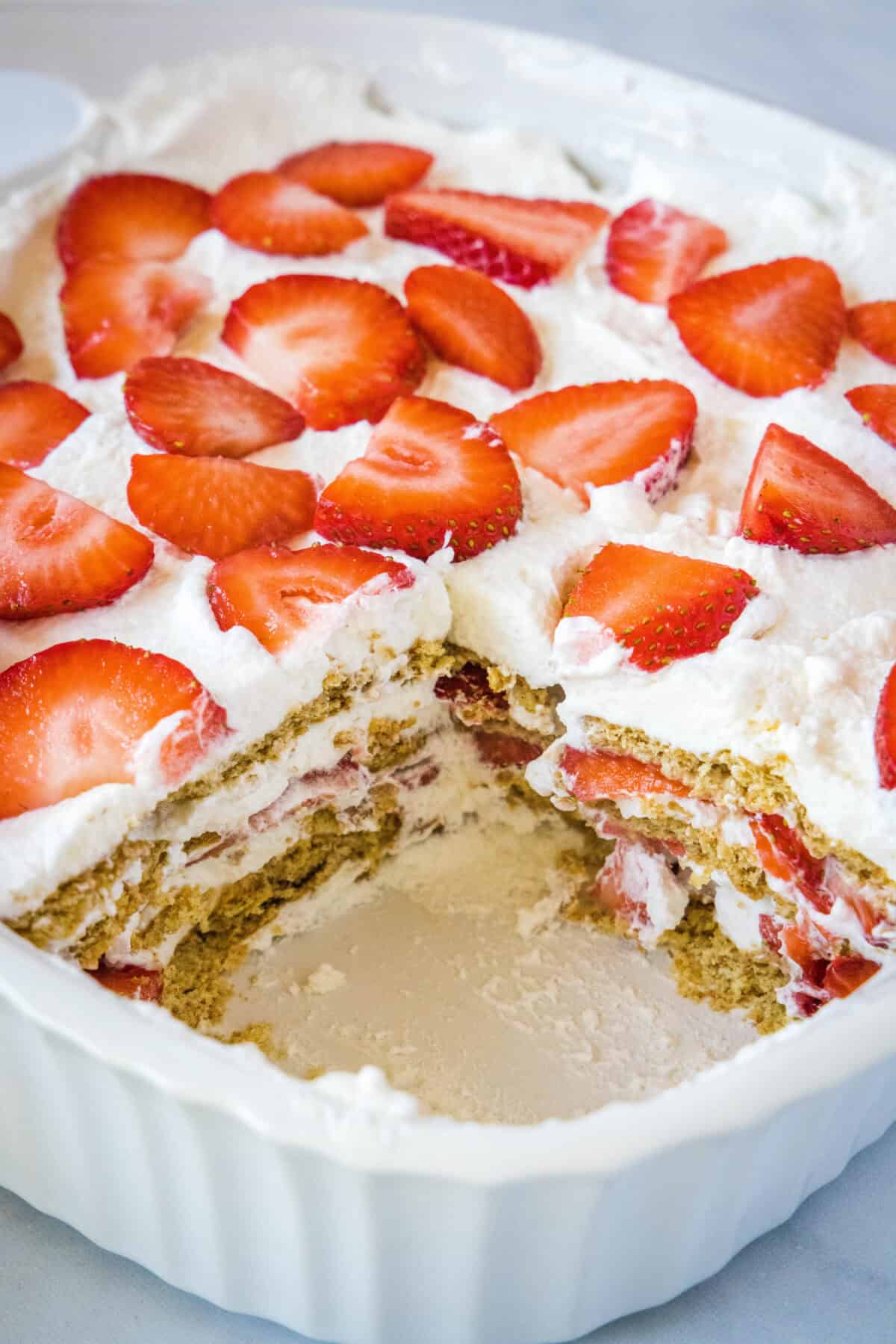 strawberry ice box cake in pan with piece missing