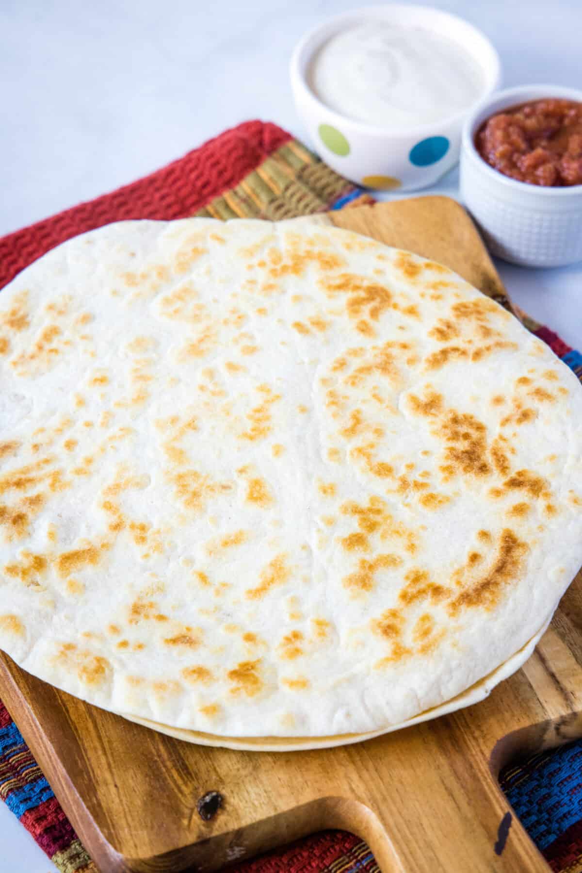 cooked chicken quesadilla on a cutting board