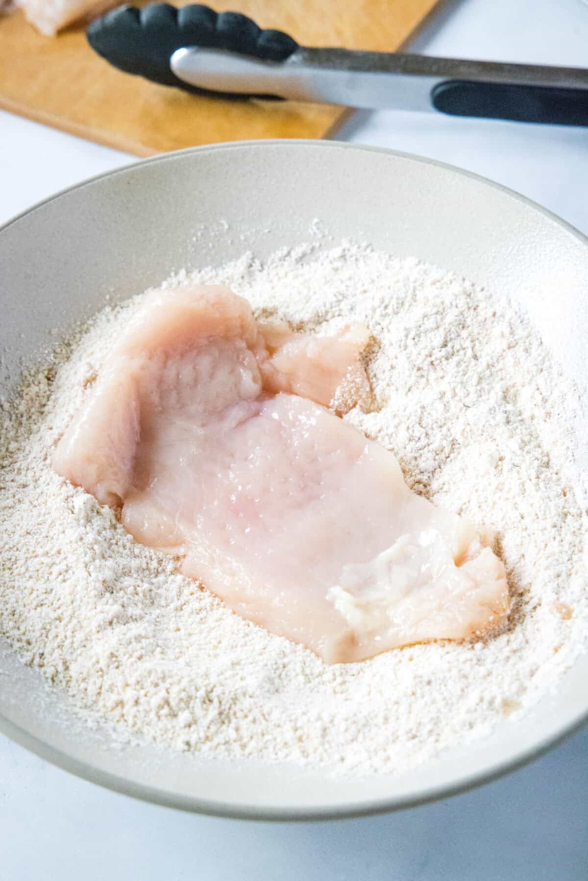 adding chicken to breading station