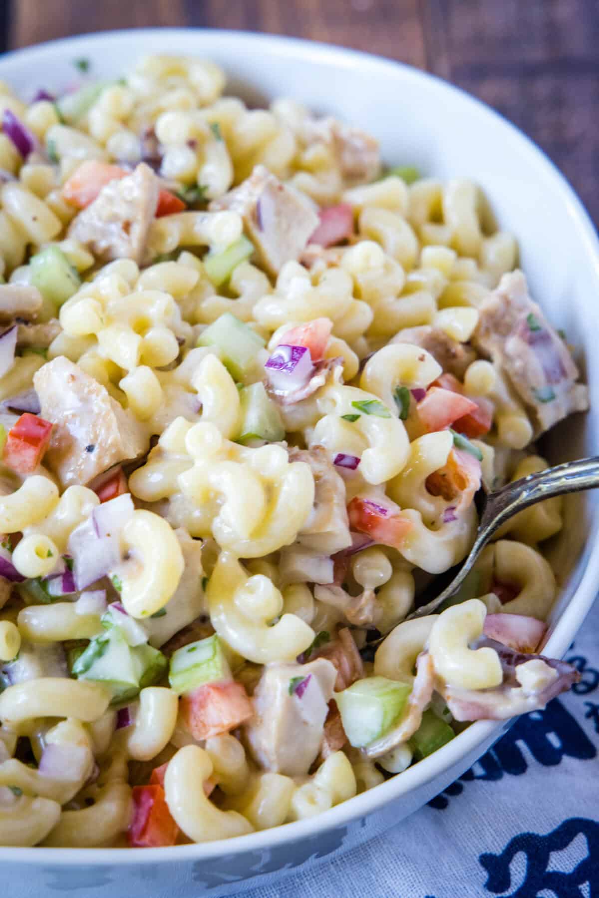 scooping chicken macaroni salad out of bowl