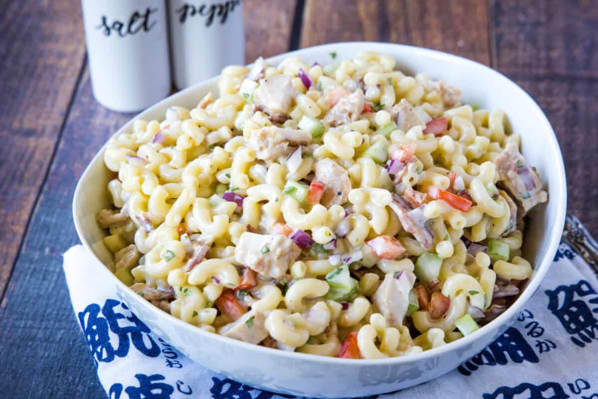 This creamy Chicken Macaroni Salad is the ultimate potluck side dish! Tender chicken, crispy bacon, celery, red onion, and bell pepper get tossed in a tangy homemade dressing for the coziest pasta salad recipe. Make it ahead for your next BBQ, picnic, or family dinner!