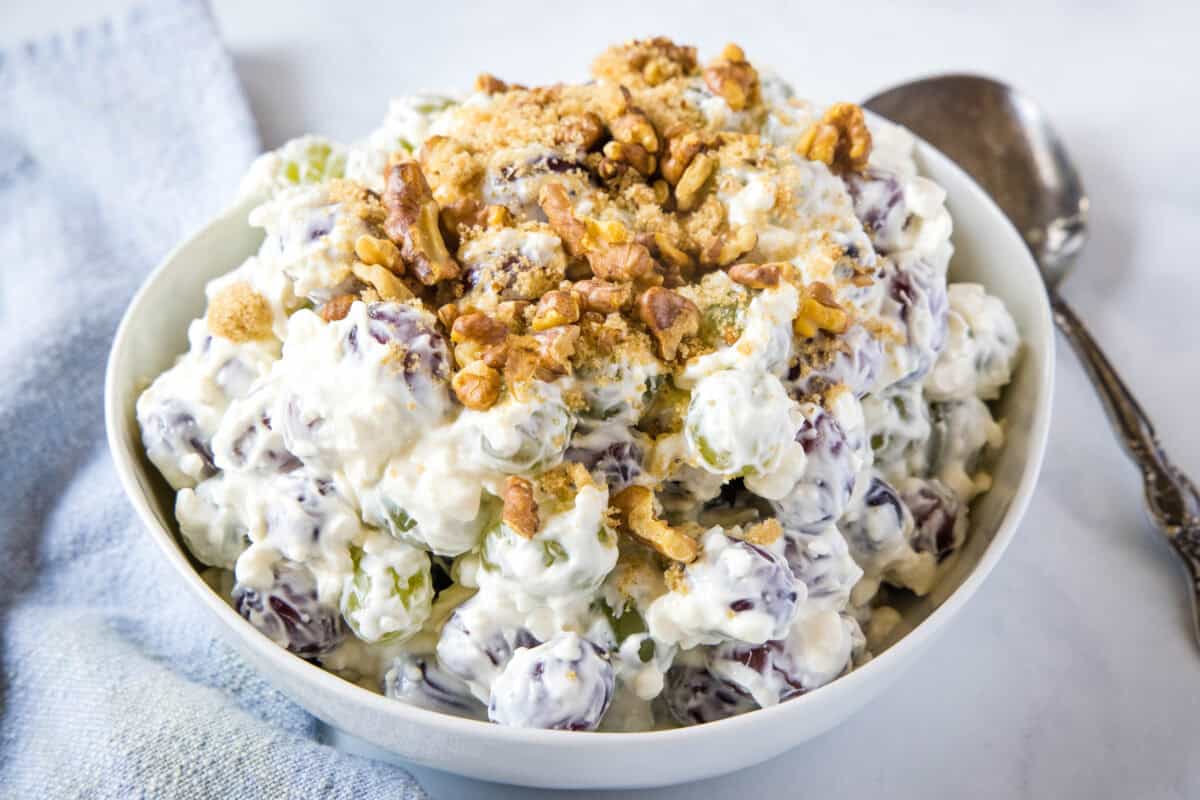 This classic Grape Salad recipe combines sweet red and green grapes in a creamy cream cheese dressing, topped with brown sugar and crunchy walnuts. Ready in 10 minutes!