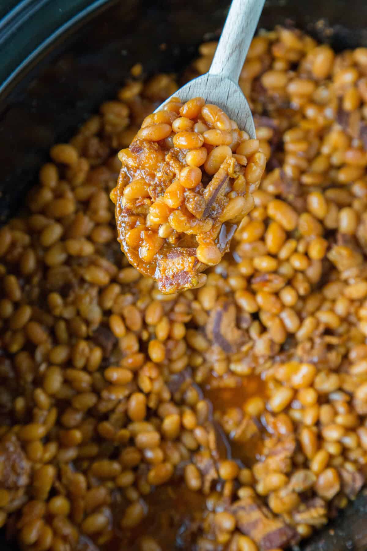 scooping baked beans from crockpot