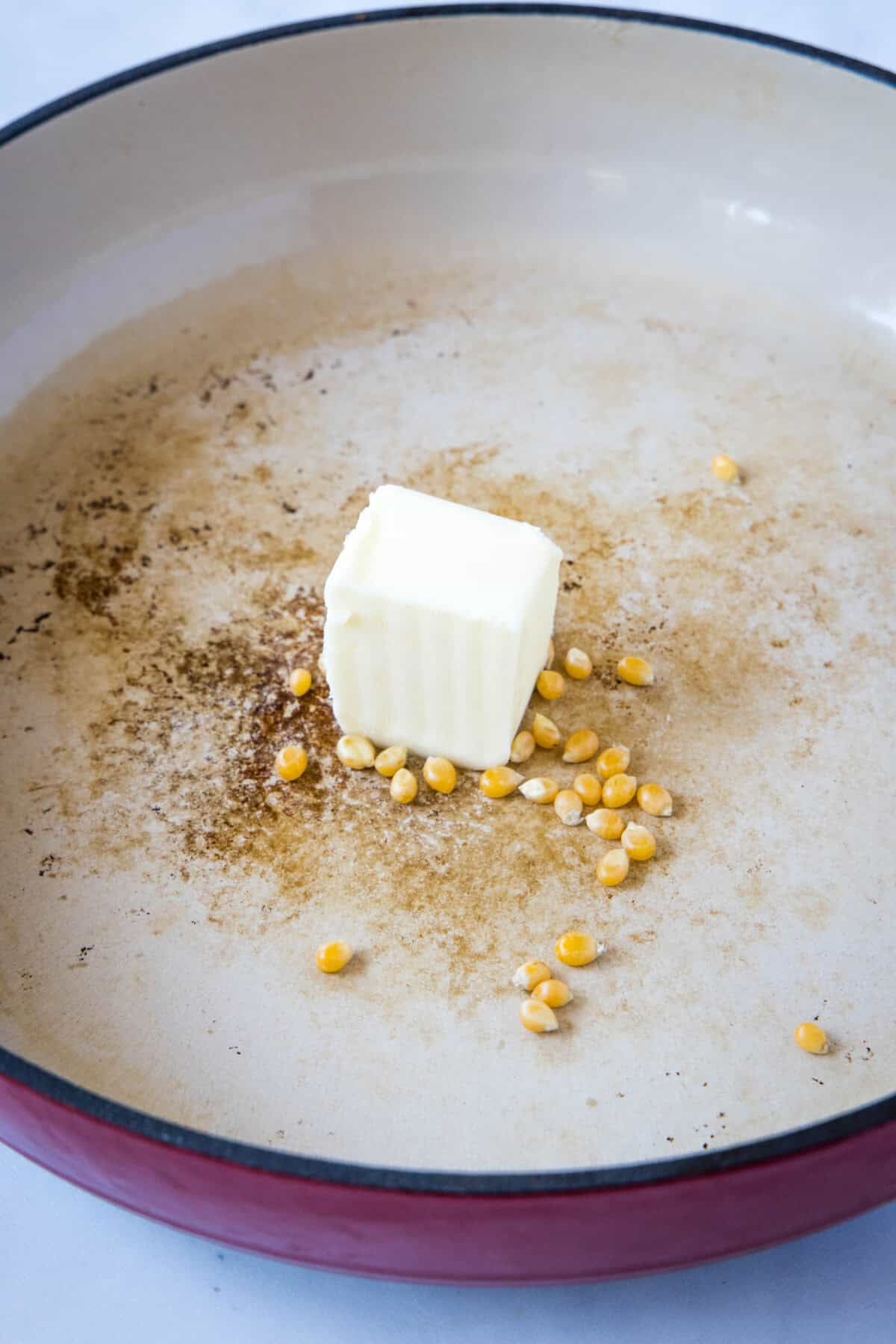 butter and popcorn kernels in pan