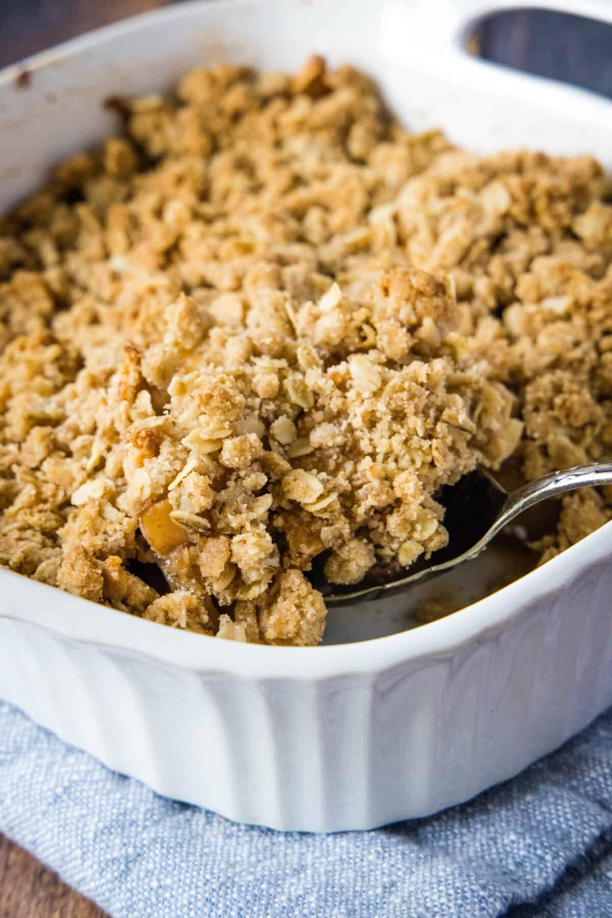 scooping apple crisp out of baking pan