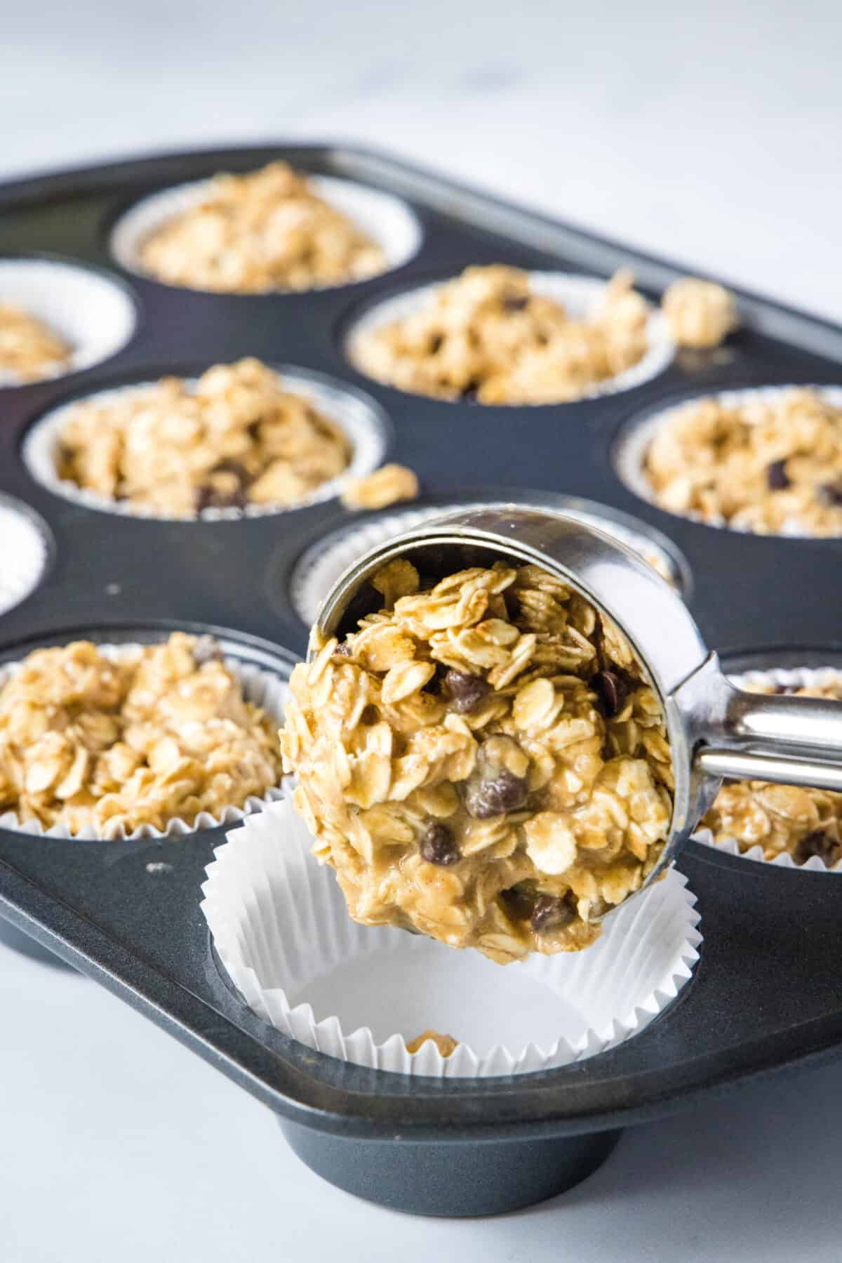 scooping oatmeal cups into muffin pan