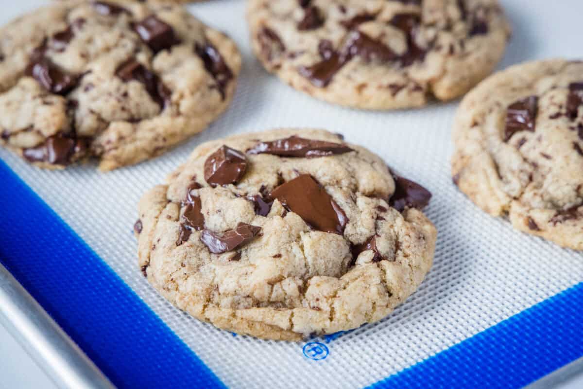 Bakery style chocolate chip cookies with crisp caramelized edges and soft, gooey centers. Browned butter and a corn syrup trick keep them chewy for days.