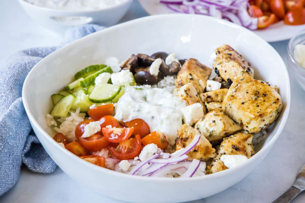Chicken Gyro Bowls with marinated Greek chicken, homemade tzatziki, and fresh veggies over rice make an easy, healthy weeknight dinner.