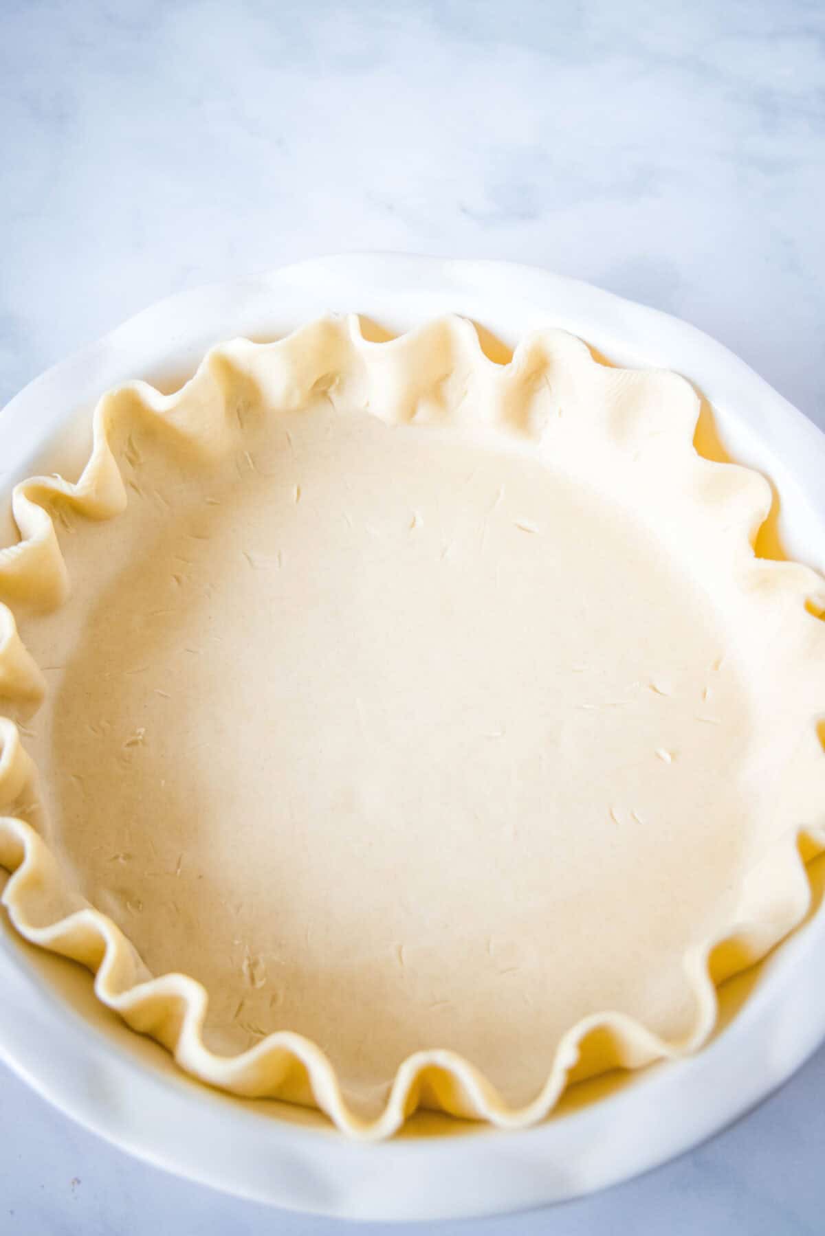 raw pie crust in a pie plate