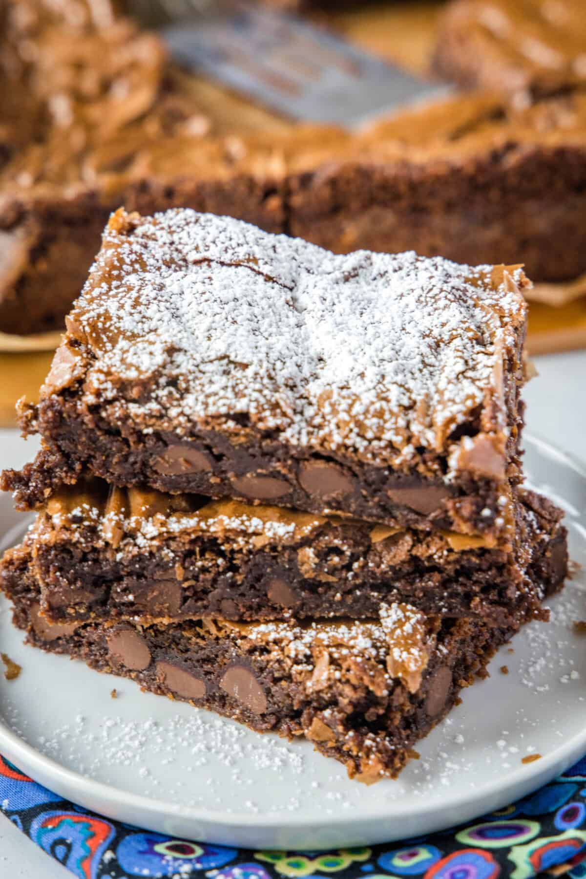 nutella brownies stacked on a white plate topped with powdered sugar