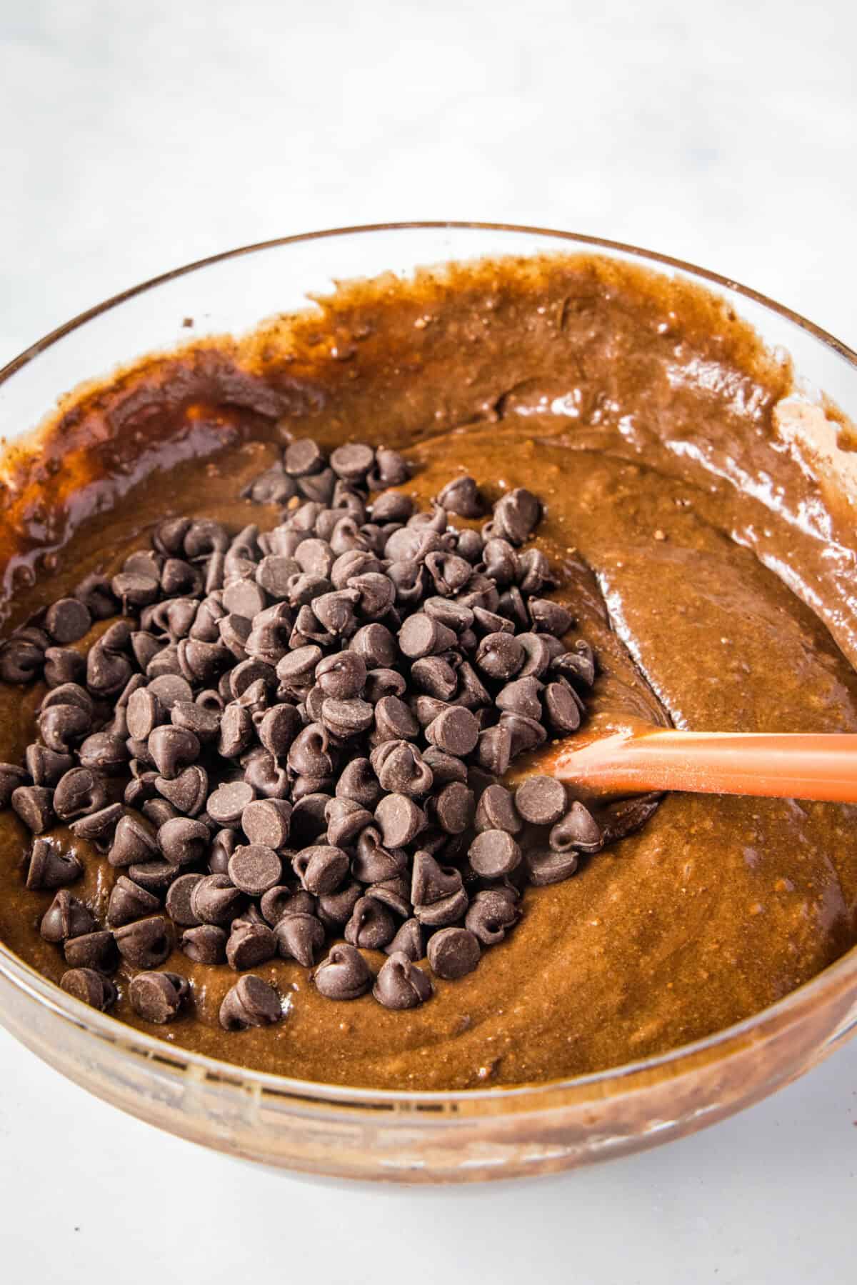 adding chocolate chips to brownie batter