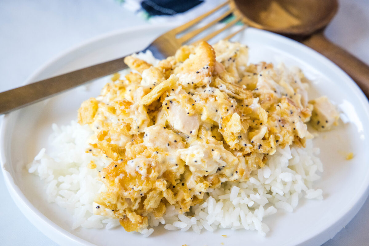 poppy seed chicken over rice on a white plate