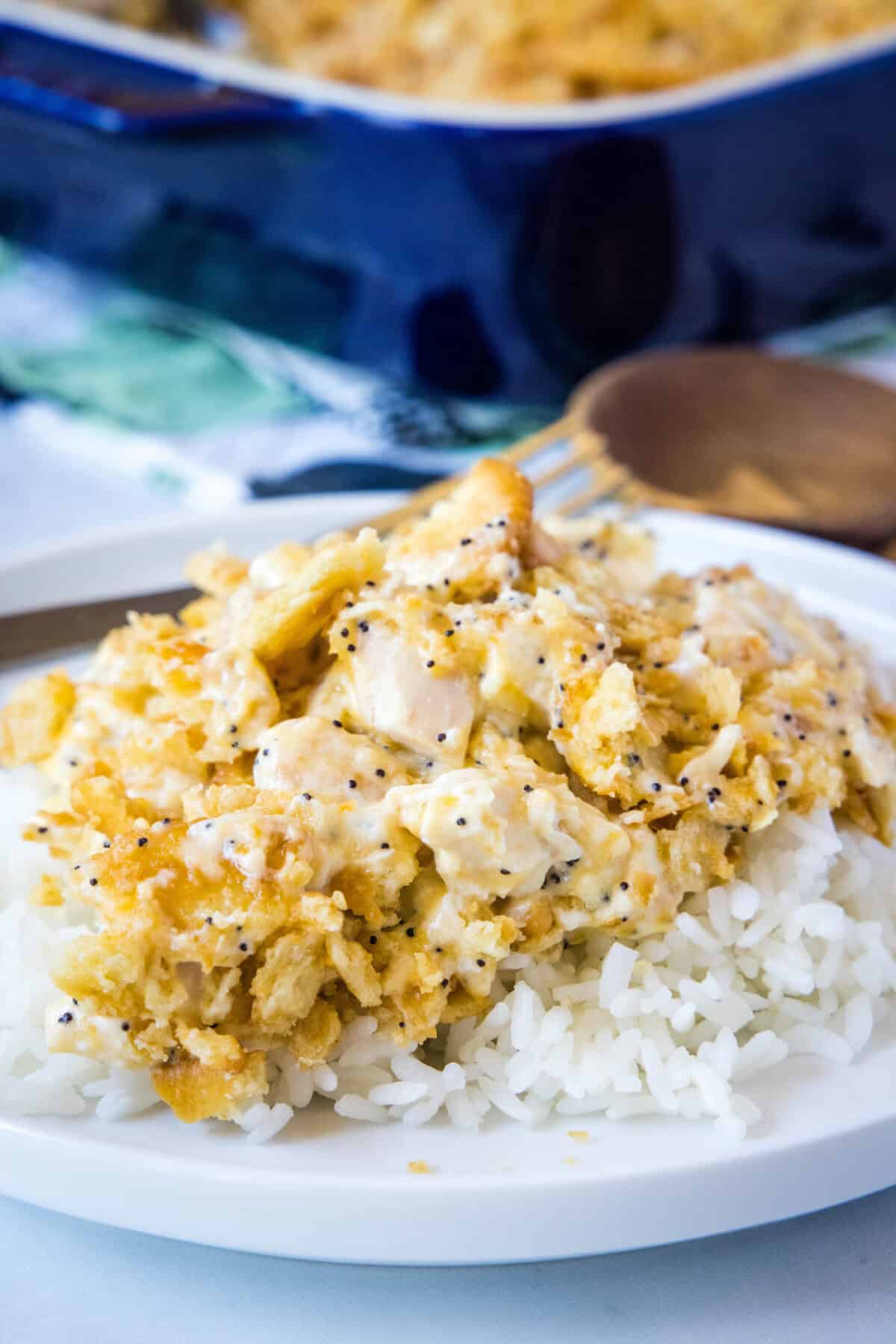 poppy seed chicken over rice on a white plate