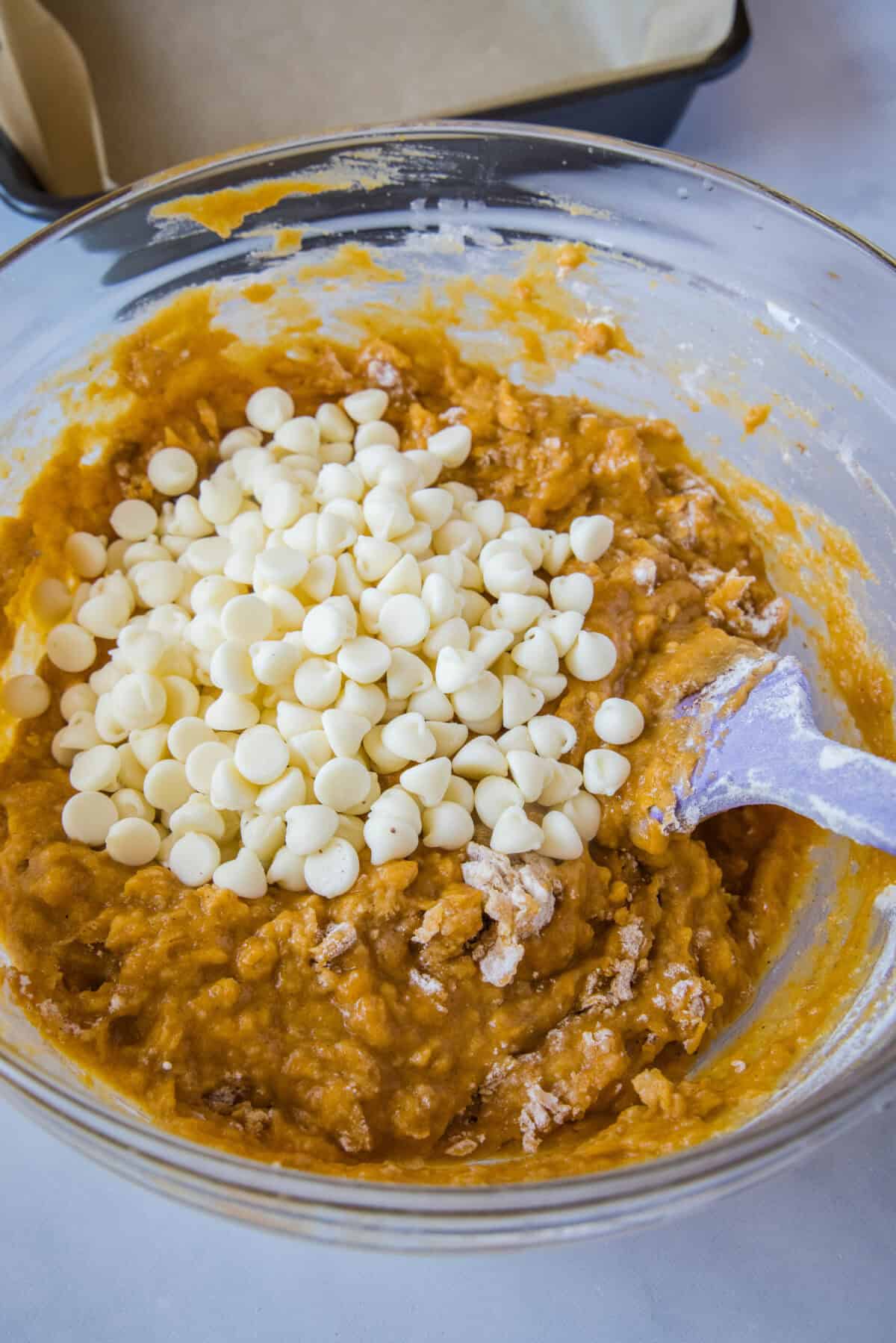 adding white chocolate chips to pumpkin blondie batter