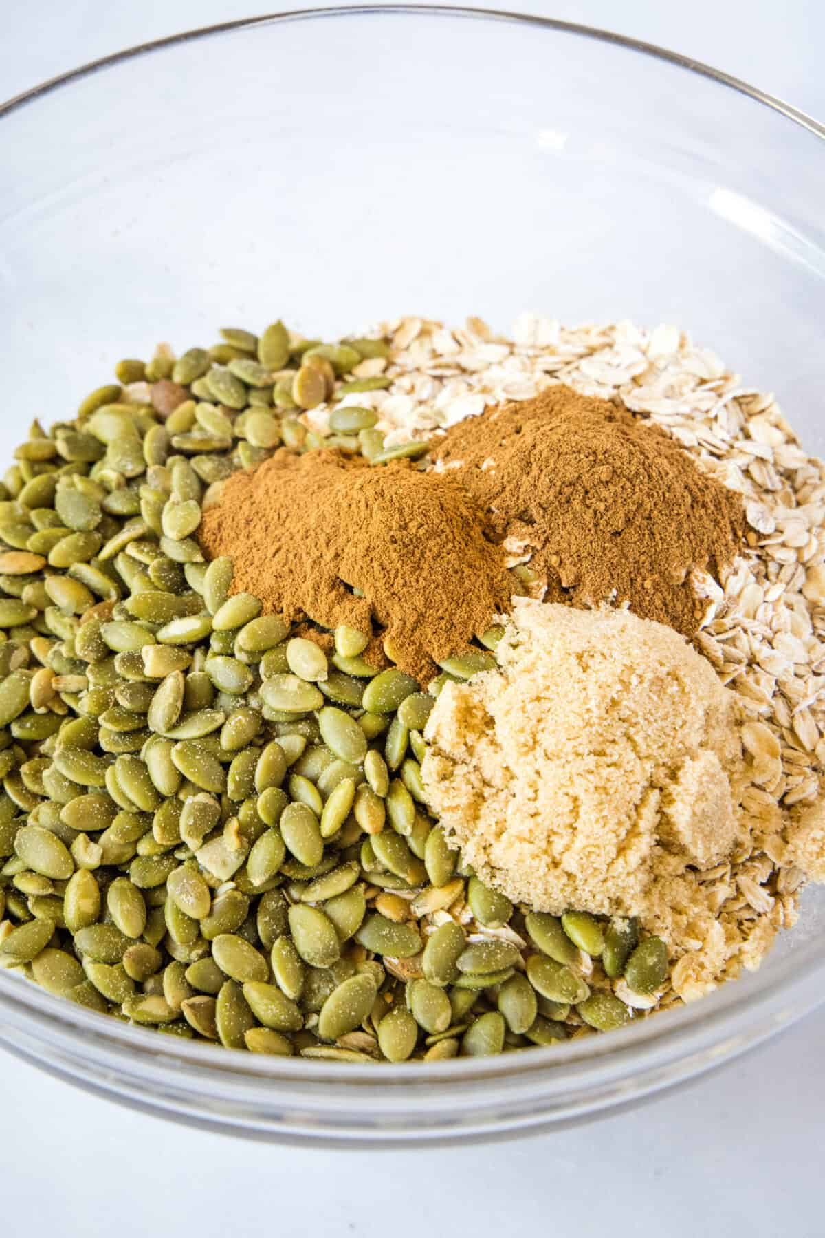 dry pumpkin granola ingredients in mixing bowl