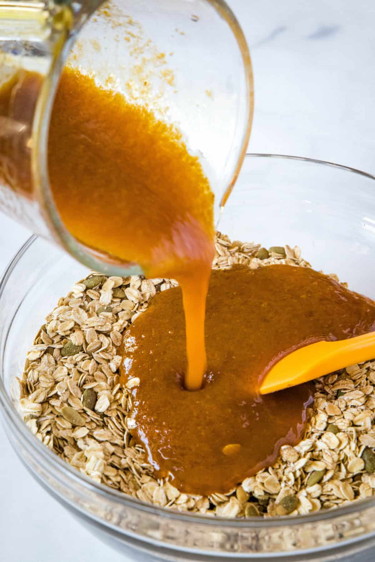 adding liquid ingredients to oats in mixing bowl