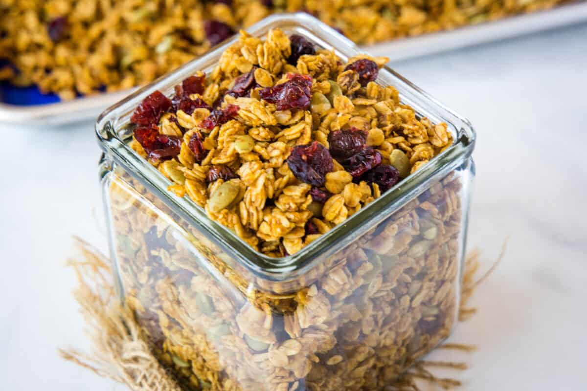 Pumpkin granola is loaded with cinnamon, pumpkin puree, pumpkin seeds, and dried cranberries for the ultimate cozy fall breakfast or snack.