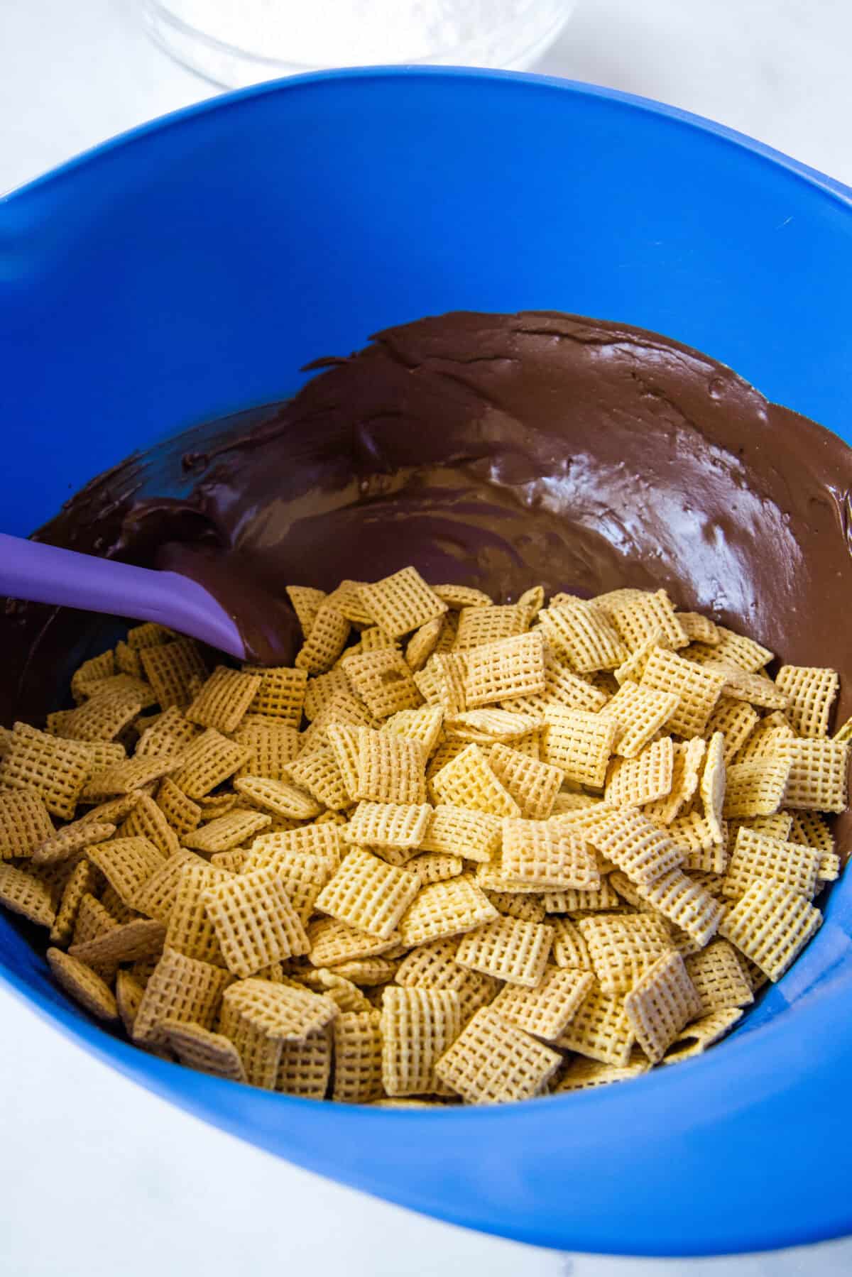 adding corn chex to melted chocolate