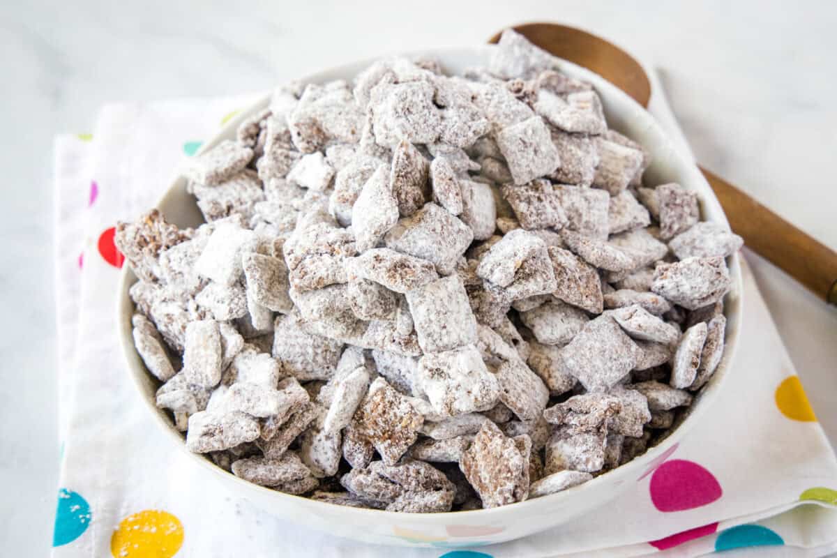 This Puppy Chow recipe (Muddy Buddies) is loaded with extra chocolate and peanut butter for the best clumpy bites. Ready in 15 minutes, no oven needed!