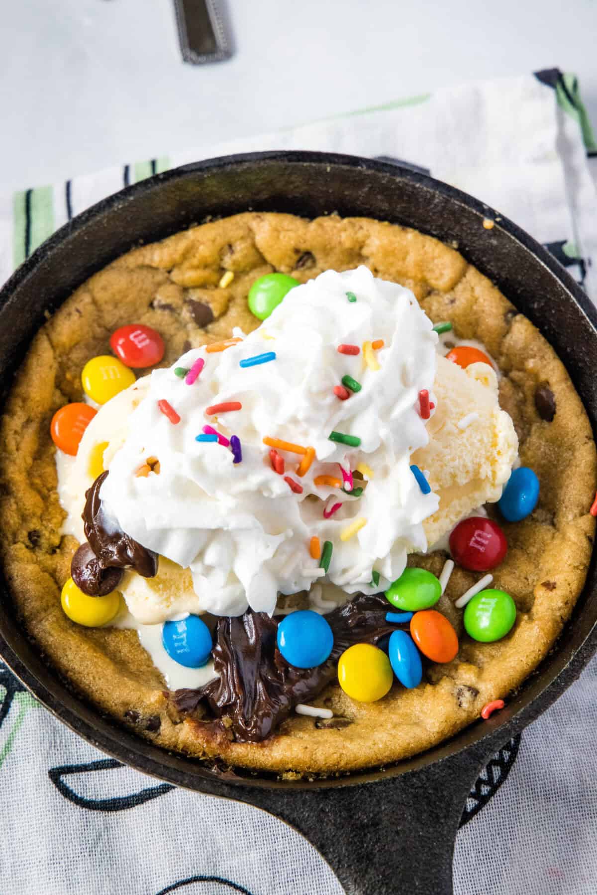 looking down on skillet cookie with whipped cream and toppings