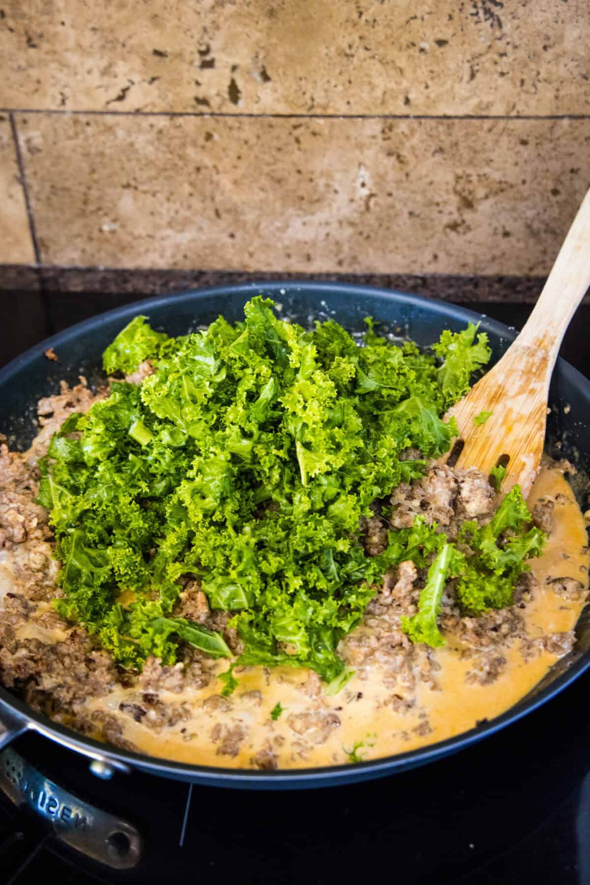 adding kale to the skillet