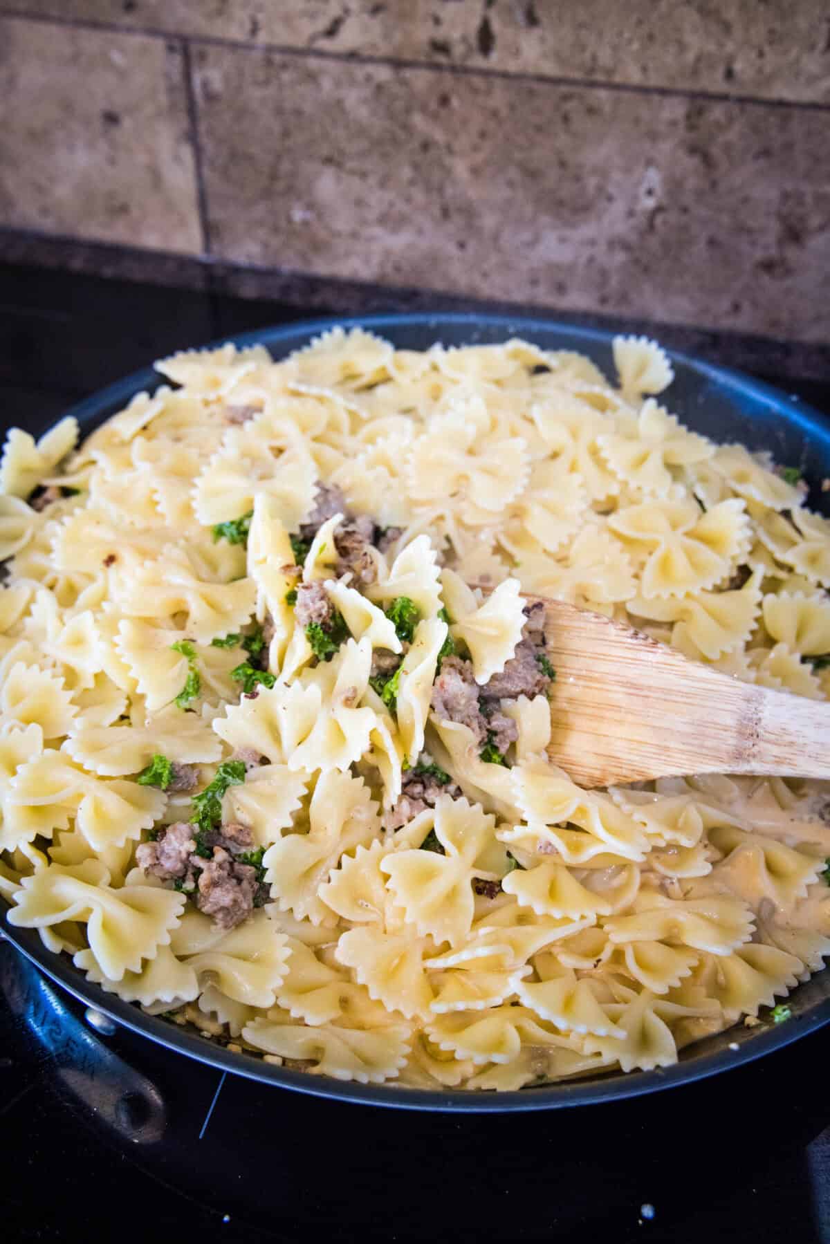 adding cooked pasta to the skillet