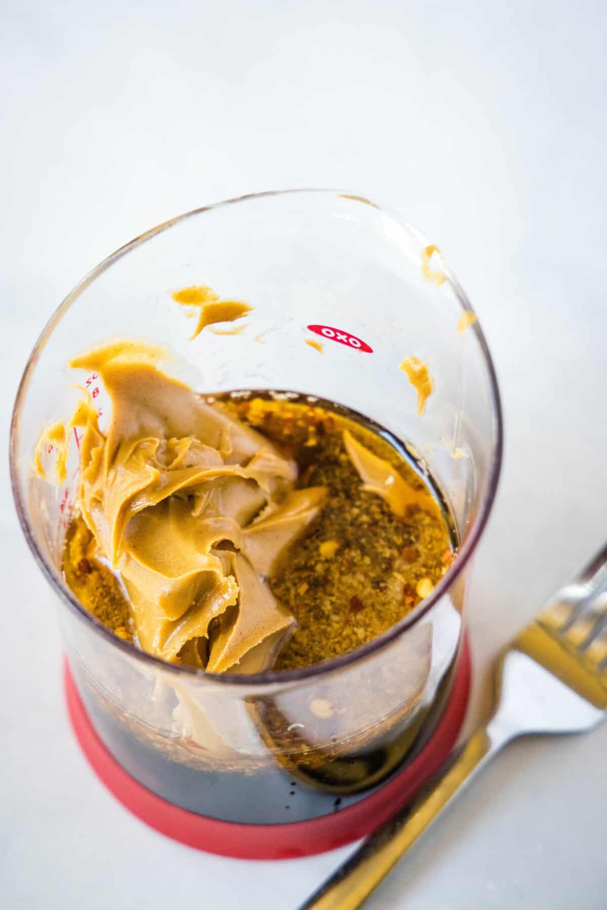 thai peanut sauce ingredients in measuring cup