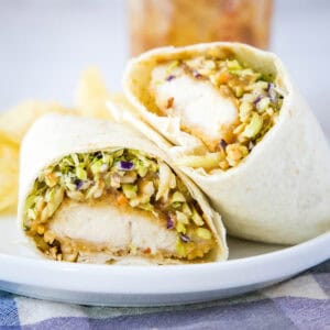 close up asian chicken wrap cut in half on plate