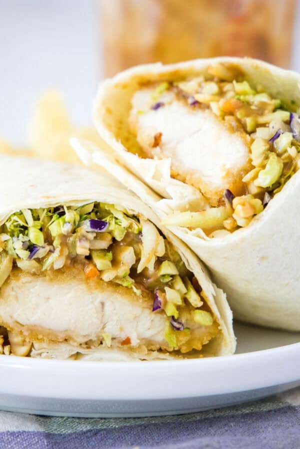 close up asian chicken wrap cut in half on plate
