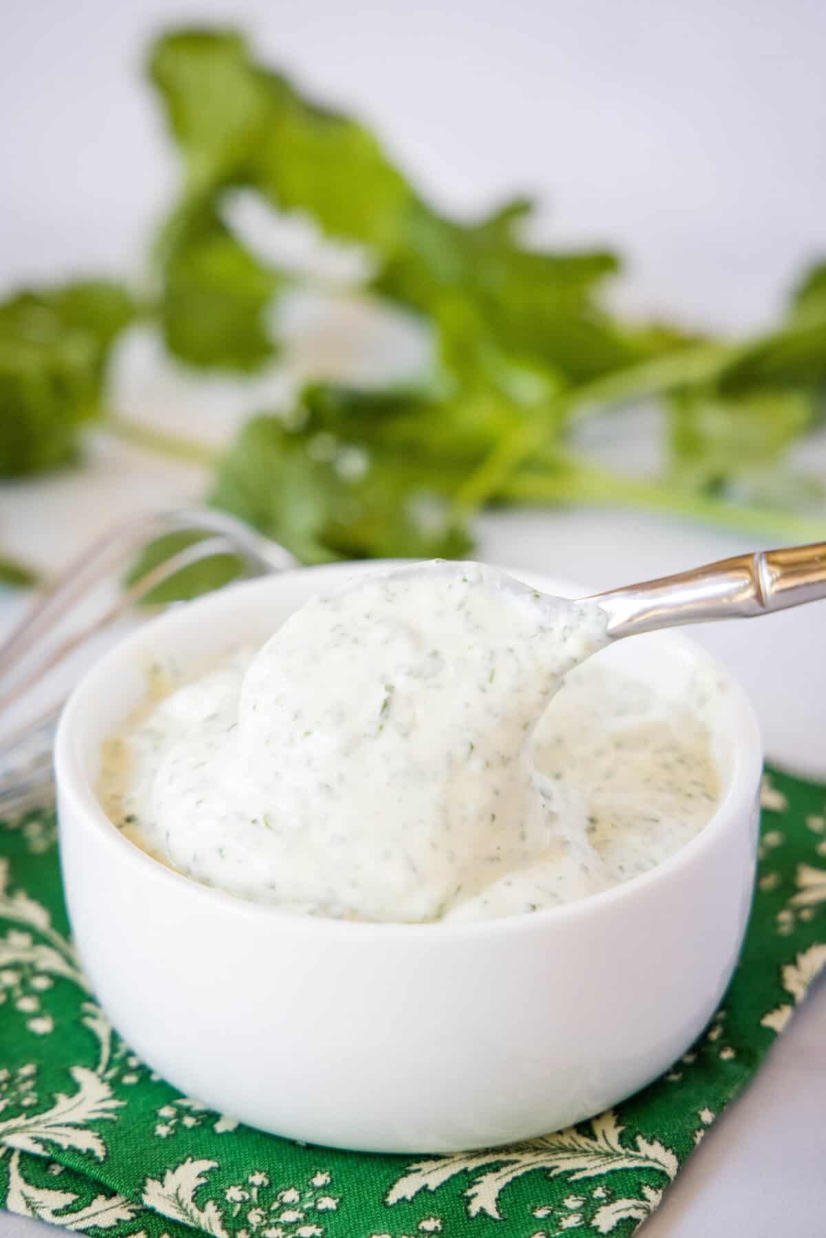 spooning cilantro lime crema out of bowl