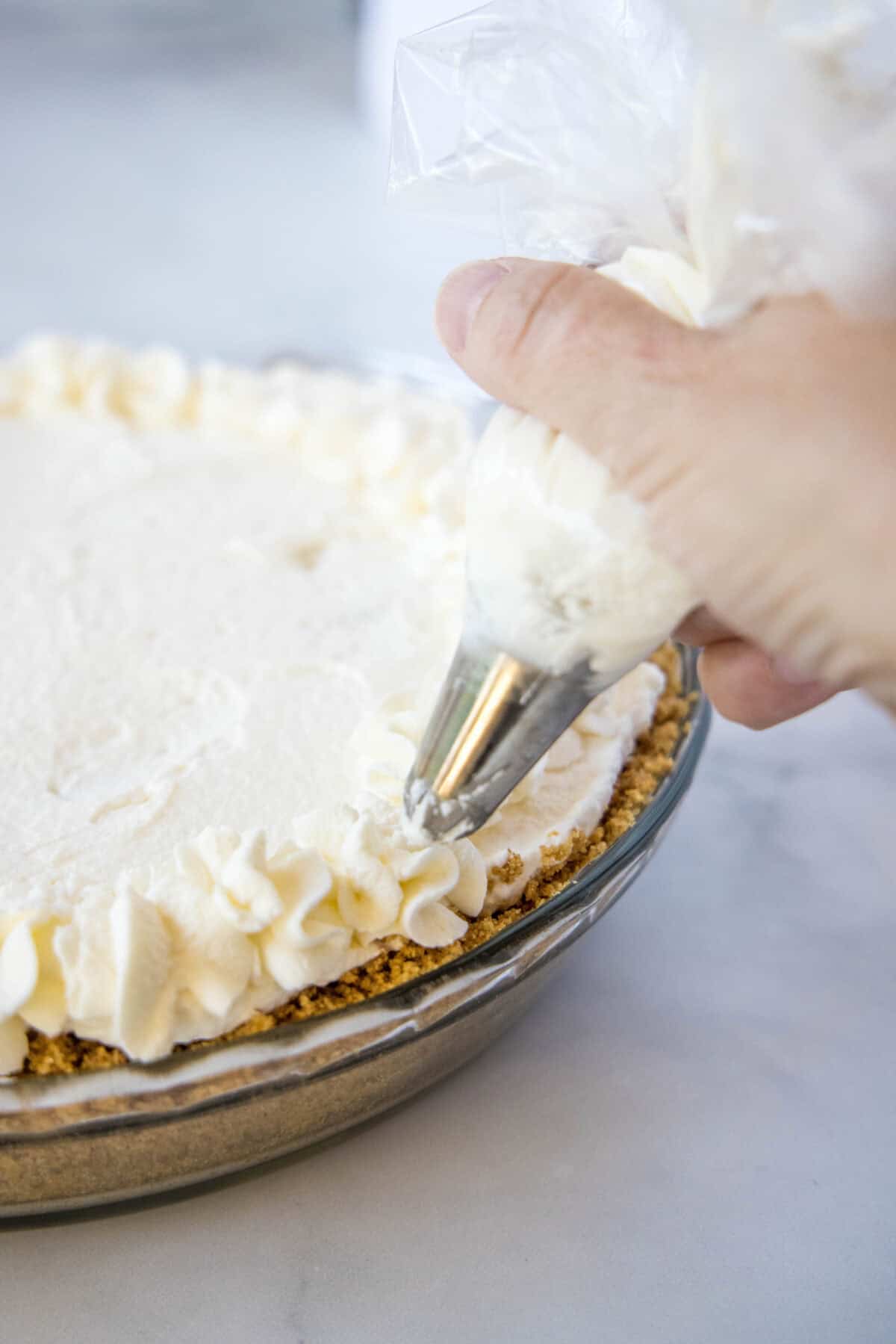 piping whipped cream on top of pie