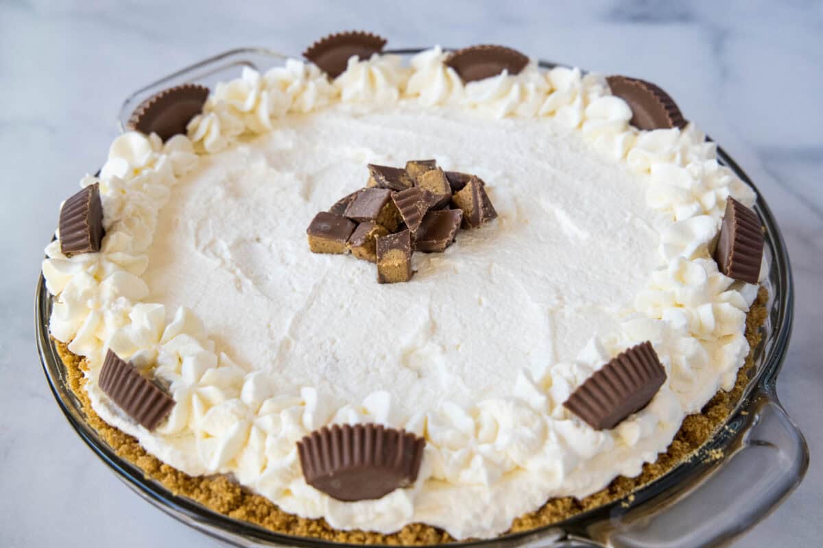 Peanut Butter Cream Pie is a no-bake dessert with a graham cracker crust, hot fudge layer, creamy peanut butter filling, and fresh whipped cream on top.