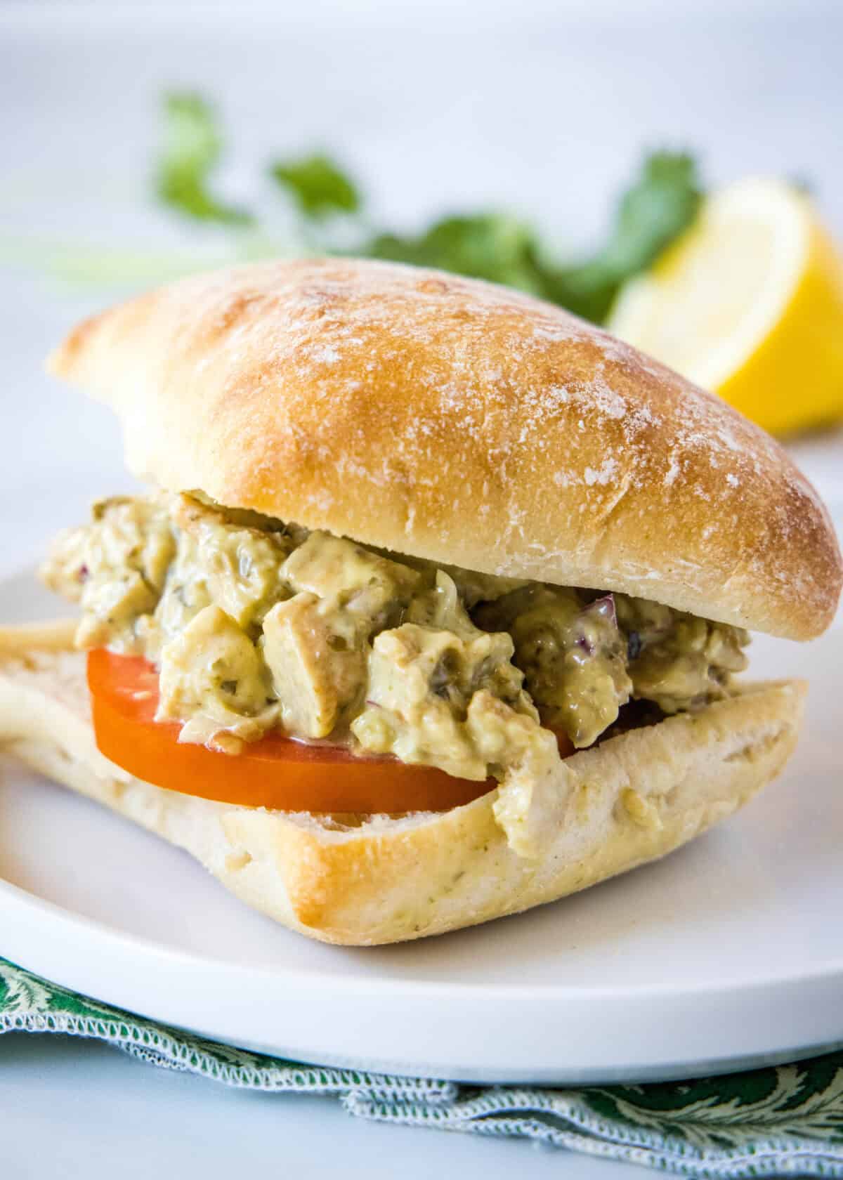 pesto chicken salad on a roll with tomato