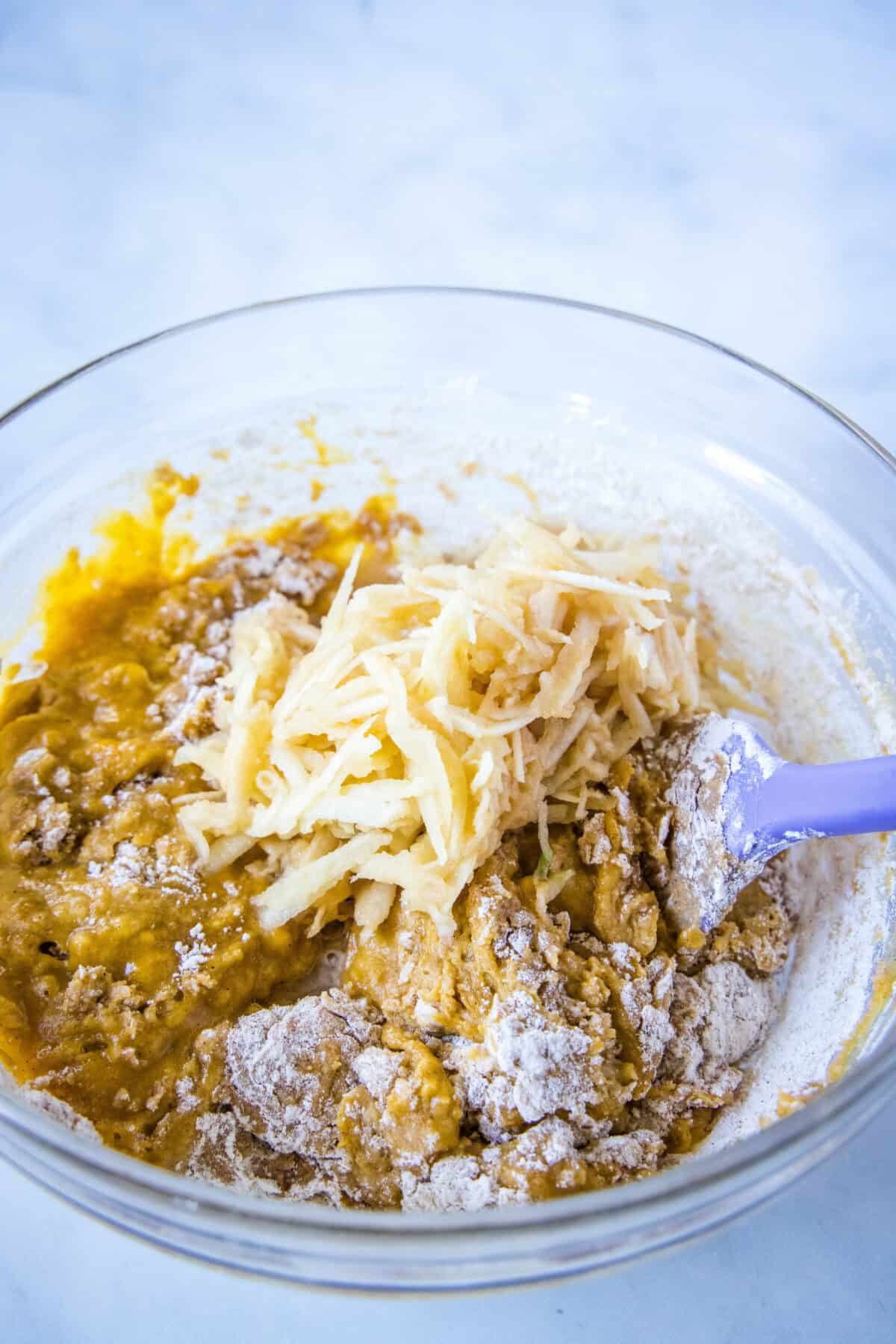 adding shredded apple to pumpkin coffee cake batter
