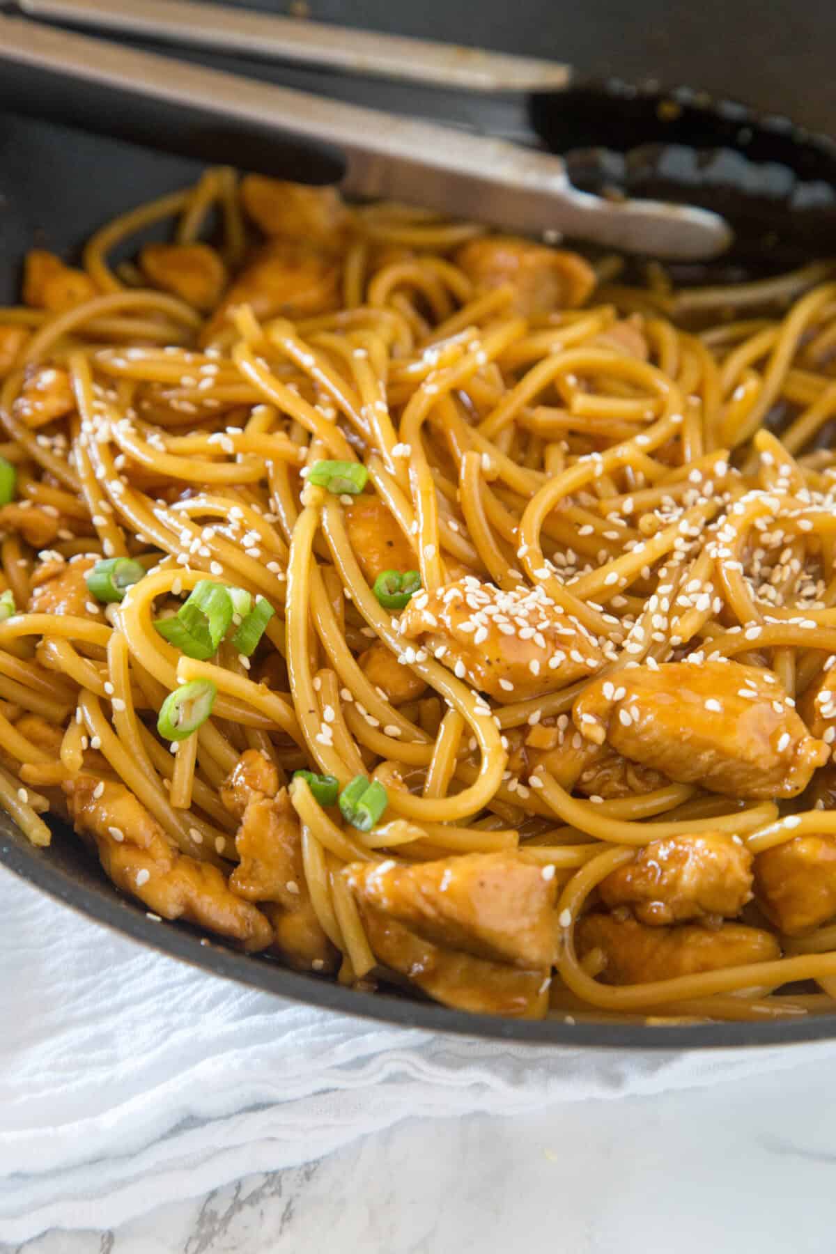 looking down on teriyaki chicken noodles in a skillet