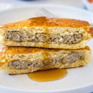 close up sausage pancakes cut in half on a plate